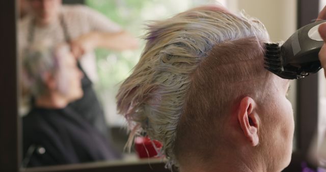 Hands of caucasian male hairdresser using clippers on hair of female client at salon, copy space. Hairdressing, hairstyling, fashion, style, local business, service and hair salon, unaltered.