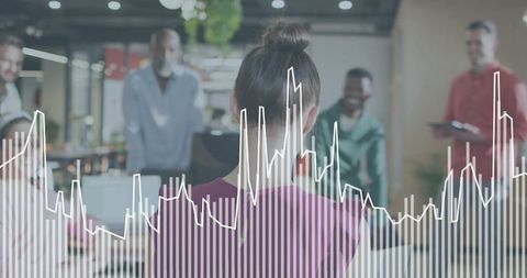 Mid-adult woman presenting data in modern open-plan office with team collaboration