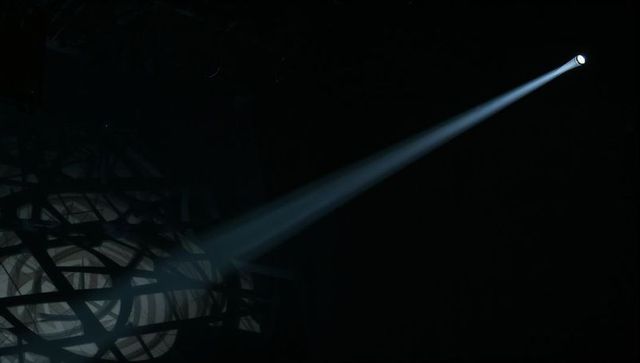 Spotlight Cutting Through Haze Casting Woven Sphere into Dramatic Noir Shadows