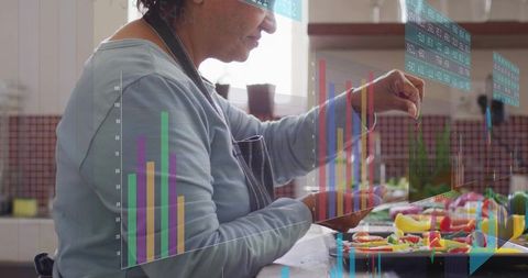 Senior indian cook slicing vegetables with digital data overlay and kitchen dashboard