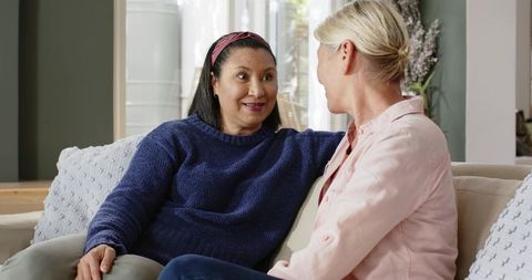 Diverse Mature Female Friends Chatting on Comfortable Sofa