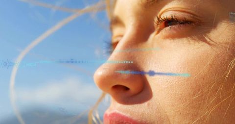 Woman soaking in warm sunlight at coastal horizon, closeup with blue waveform overlay