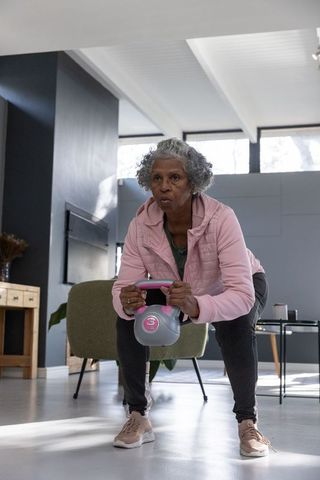 Senior Woman Exercising with Kettlebell in Modern Home Setting