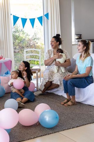 Diverse Female Friends Celebrating Baby Shower with Joyful Balloon Décor