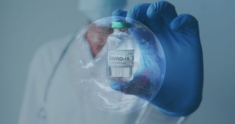 Scientist Holding COVID-19 Vaccine with Globe Overlay - Download Free Stock Images Pikwizard.com