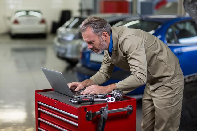 Mechanic using laptop in repair garage