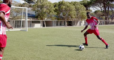 Young Athletes Dribbling Soccer Ball on Field