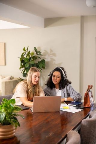 Diverse female coworkers collaborating on project at modern office workspace
