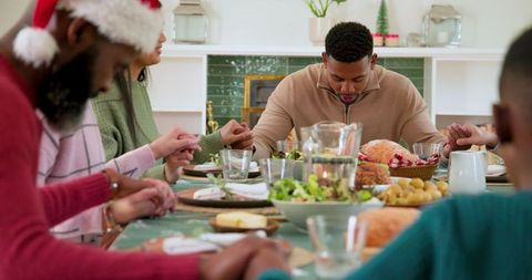 Family Praying Together at Festive Dinner Table