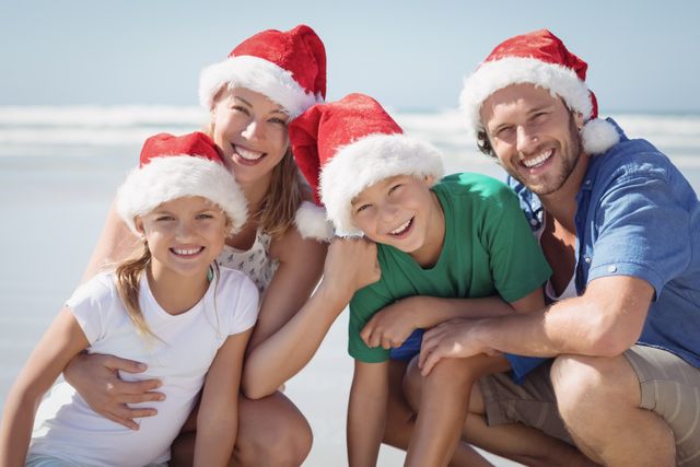 Family enjoying a sunny day at the beach while wearing Santa hats. Perfect for holiday-themed promotions, travel advertisements, and festive greeting cards. Highlights the joy of spending Christmas holidays in a warm, beach setting.