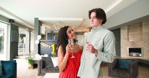 Couple celebrating anniversary with champagne in modern living room