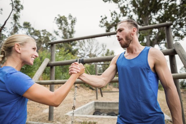 Fit man and woman greetings during obstacle course at boot camp