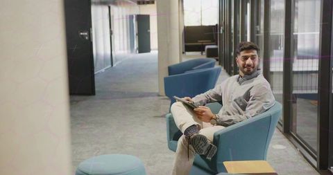 Businessman Relaxing in Modern Office Lounge Using Digital Tablet