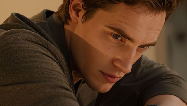 Leaning young man focusing in warm light closeup portrait with pensive expression