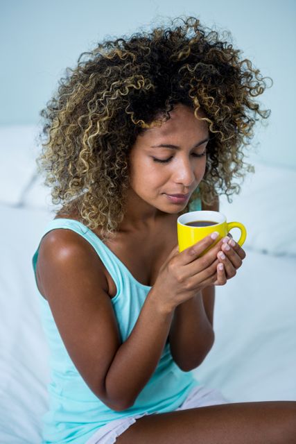 Young woman drinking a coffee on bed - Download Free Stock Photos Pikwizard.com