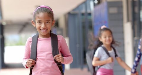 Smiling Schoolgirl With Backpack in Hallway, Friends Behind - Download Free Stock Images Pikwizard.com