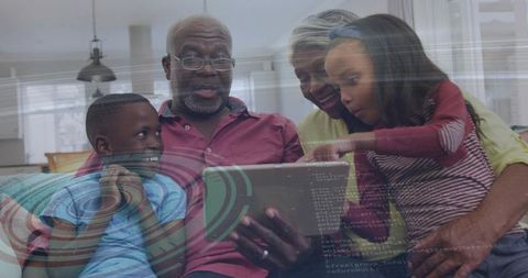 Intergenerational family exploring tablet together with digital overlay and coding graphics