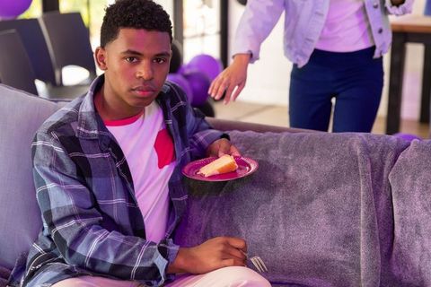 Teen enjoying cake during vibrant home celebration