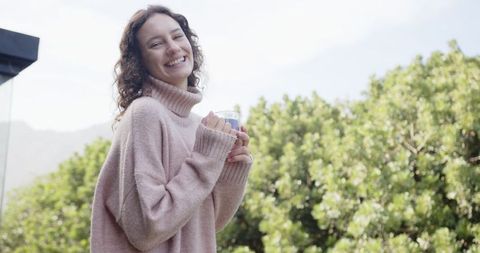 Joyful Woman Relaxing with Coffee on Scenic Balcony