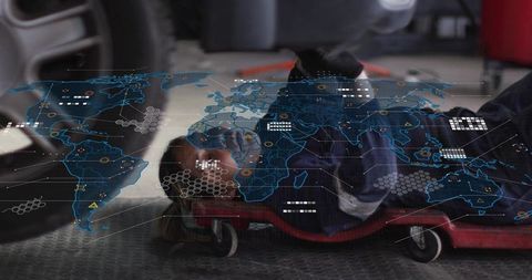 Female mechanic inspecting car underside with augmented reality overlay for diagnostics