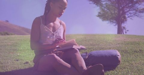 Woman Relaxing on Hillside Reading Paperback Outdoors