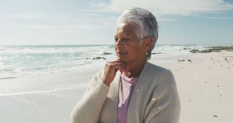 Senior Woman Reflecting on Beach with Ocean Waves