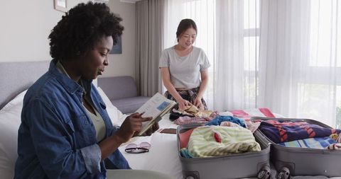 Interracial Couple Packing Suitcase for Summer Vacation