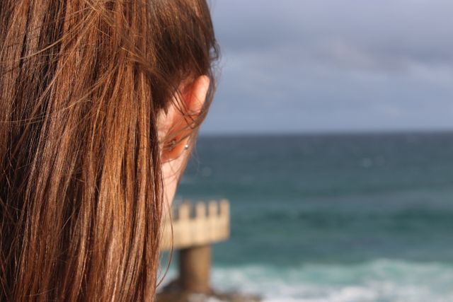 Woman with Long Brown Hair in Deep Thought Overlooking Ocean - Download Free Stock Images Pikwizard.com