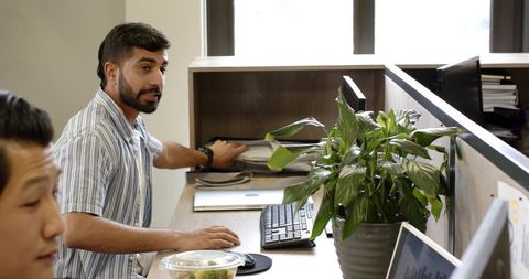 Diverse Team Collaborating in Open Office Workspace with Technology