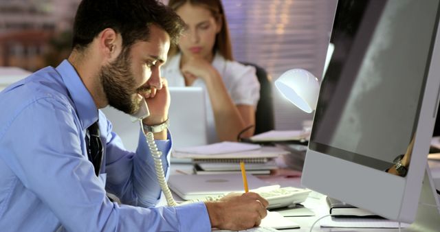 Young Businessman Communicating Over Office Desk Phone - Download Free Stock Images Pikwizard.com