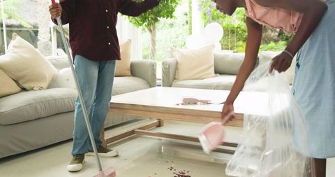 Couple Cleaning Living Room After Celebration