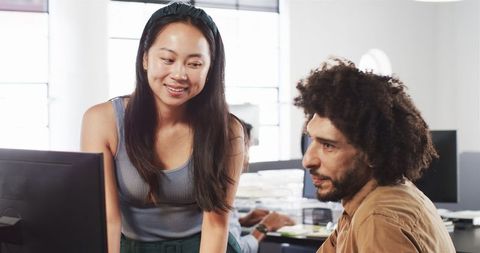Colleagues collaborating on project in modern office workspace