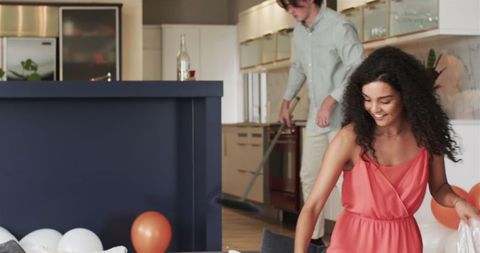 Happy couple cleaning living room after party celebration