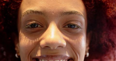 Close-Up of Smiling Woman with Hoop Earrings in Warm Lighting