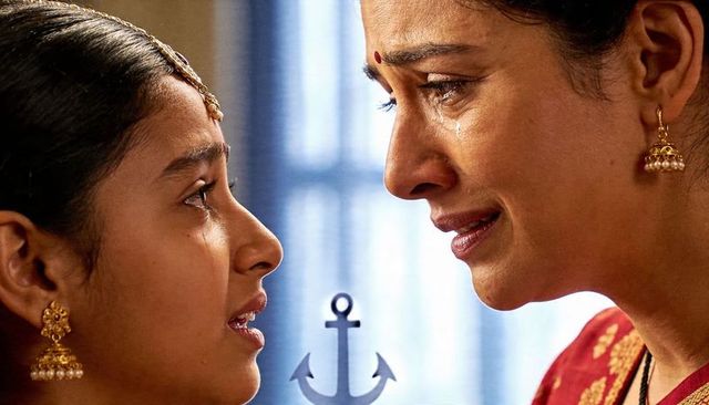 Indian mother and daughter sharing tearful moment in sari with traditional jhumkas