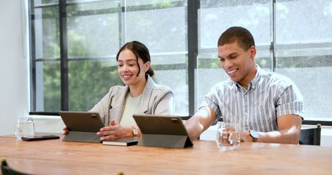 Diverse Professionals Using Tablets in Modern Work Environment