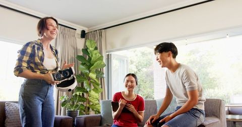 Friends Enjoying VR Gaming Experience in Bright Living Room