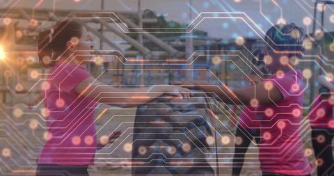 Two women lifting tractor tire at outdoor bootcamp