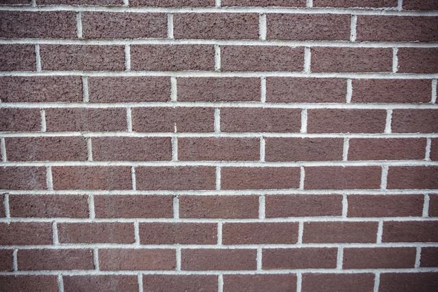 This close-up of a new brick wall showcases the texture and pattern of red bricks with white mortar. Ideal for use in construction and architecture projects, website backgrounds, or design elements emphasizing urban and industrial themes.