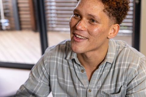 Smiling Man in Casual Shirt Enjoying a Relaxed Home Environment