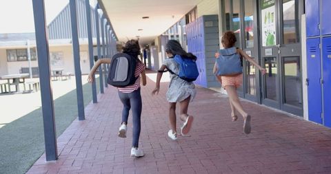 Three Lively Girls Running Through School Corridor Backpacks Cheerful Day - Download Free Stock Images Pikwizard.com