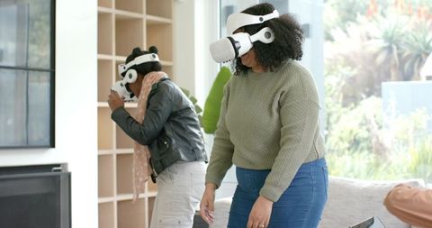 Diverse women testing wireless VR headsets in sunlit living room enjoying immersive play