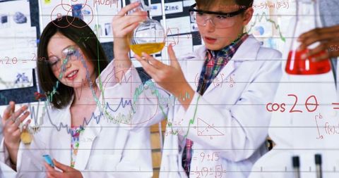 Young students holding round-bottom flask and examining colorful sample in school science lab