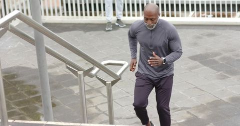 Senior African American men running up urban stairs for outdoor fitness and cardio