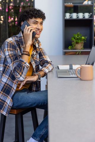 Young hispanic male engaging in work call at stylish counter