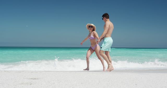 Happy couple enjoying a walk on a tropical beach - Download Free Stock Images Pikwizard.com