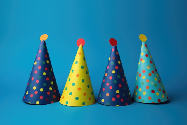 Close up of party hats on blue background, created using generative ai technology. Party, birthday party and celebration concept digitally generated image.
