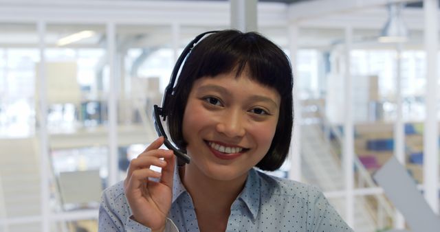 Customer service representative in office, with copy space. She wears a headset, ready to assist clients with a smile.