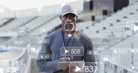 Coach at Stadium Using Tablet Surrounded by Notifications