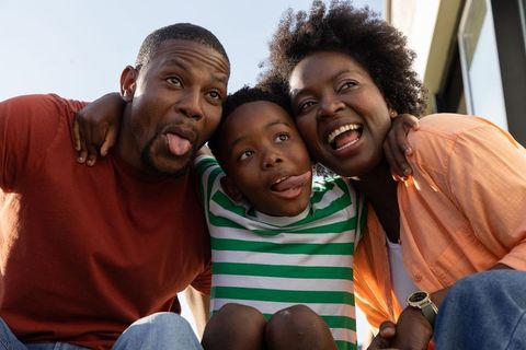 African american family laughing and making faces outdoors playful closeup